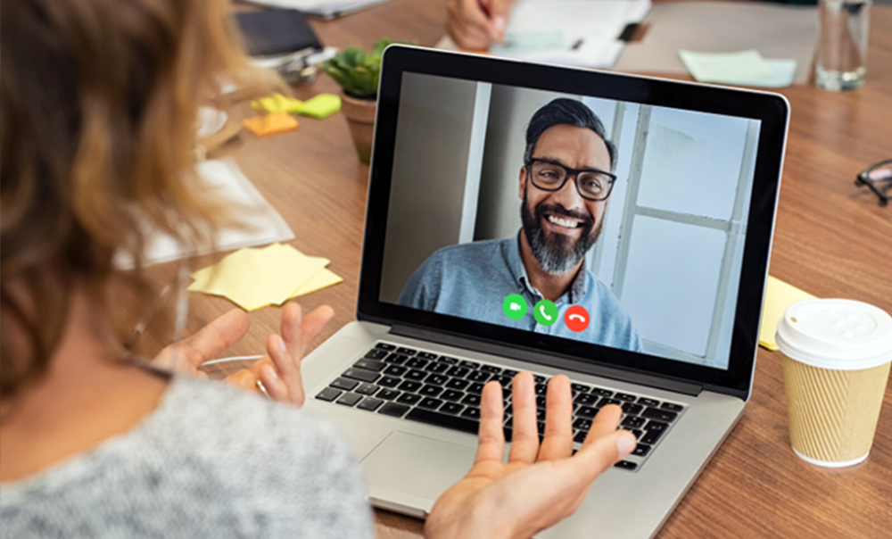 Woman talking to man on computer screen during video meeting