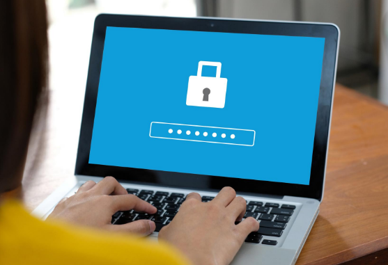 Person typing a password on a laptop