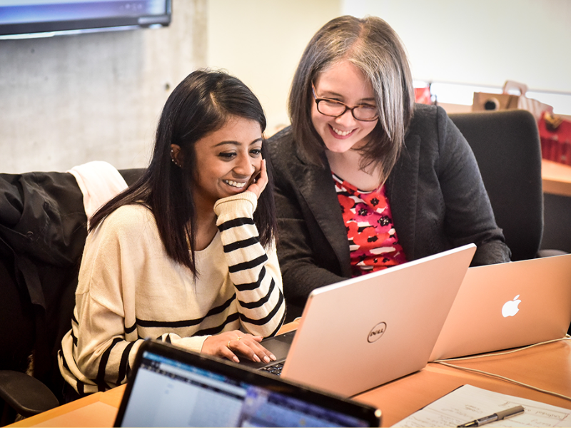 Instructor working together with a student using her laptop.