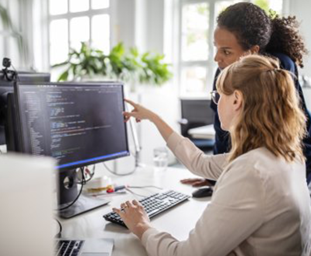 Employees collaborate together while working on a computer.