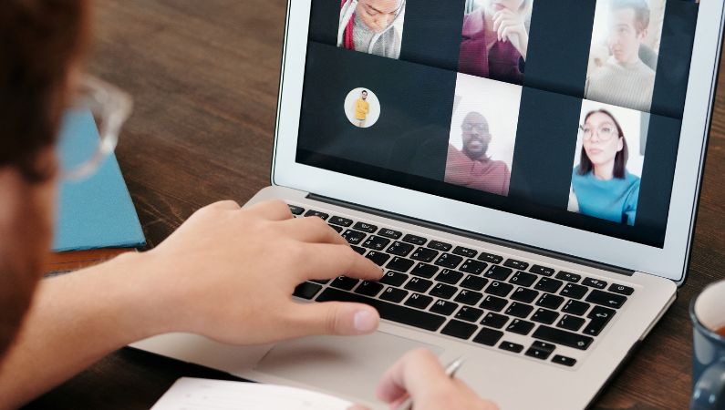 Person viewing an online meeting on a laptop