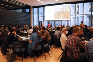 Participants sitting in round tables at the ITS all-staff meeting.